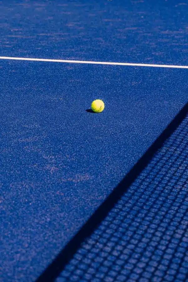 Balle de padel au milieu d'un terrain bleu