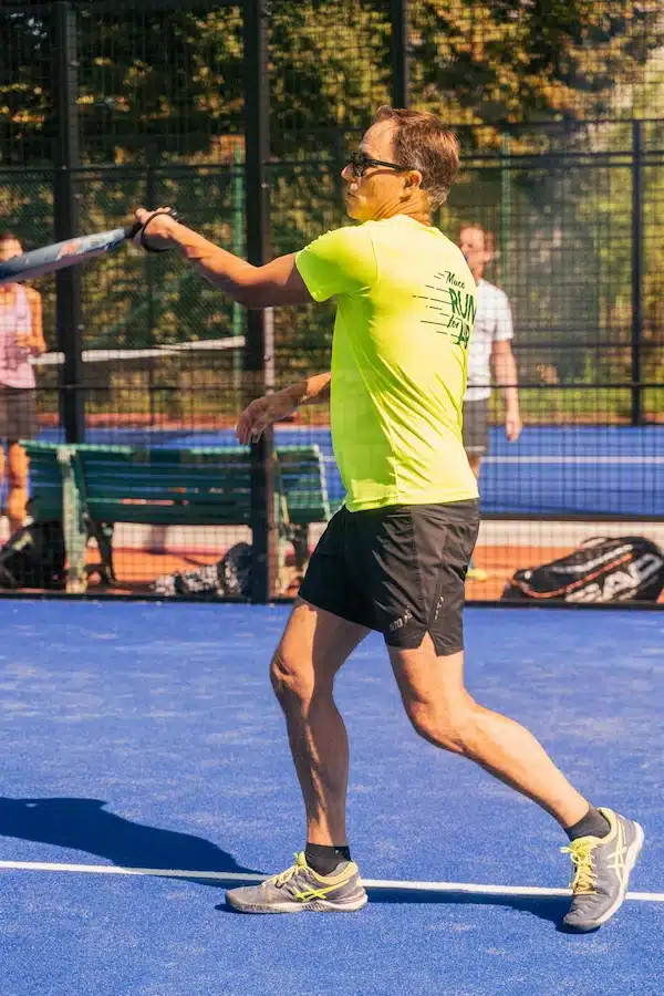 Joueur de padel en action sur un terrain extérieur