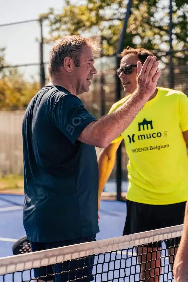 Discussion entre deux joueurs de padel près du filet