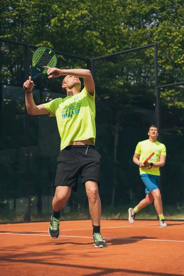 Joueur de padel à la volée devant son équipier