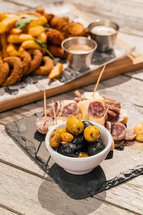 Planche apéro avec des olives, du fromage et du saucisson
